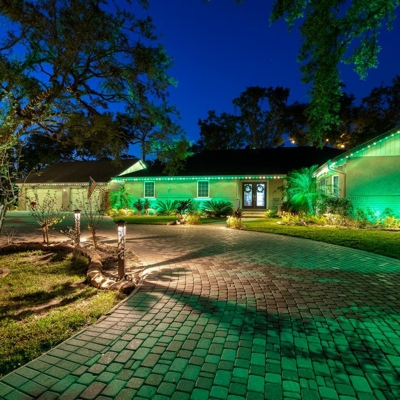 Permanent roofline lighting in green for St. Patrick's day with bollard lighting along the driveway. Photo
